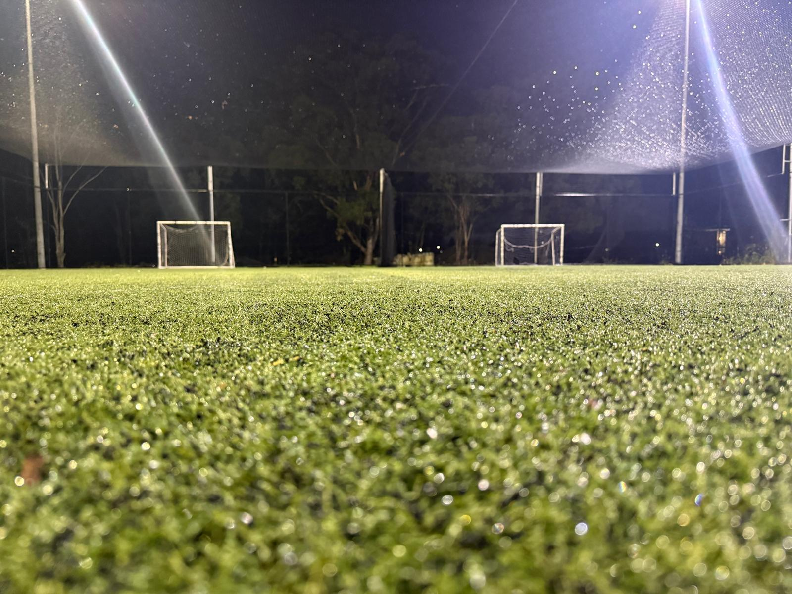 Kids playing football on Go Soccer's outdoor caged turf court in Rooty Hill
